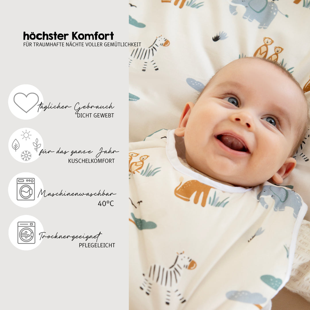 Lächelndes Baby auf der Wiegenbettwäsche "Savanna Friends", daneben Hinweis "höchster Komfort für traumhafte Nächte voller Geborgenheit" mit Produktvorteilen: dicht gewebt, kuschelig warm, maschinenwaschbar 40°C, trommeltrocknergeeignet