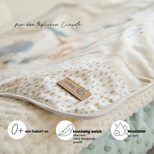 Nahaufnahme der Babydecke "Savanna Friends" mit Materialdetail und Produktvorteilen: 0+ von Geburt an, kuschelig weich, waschbar bei 30°C, für den täglichen Einsatz