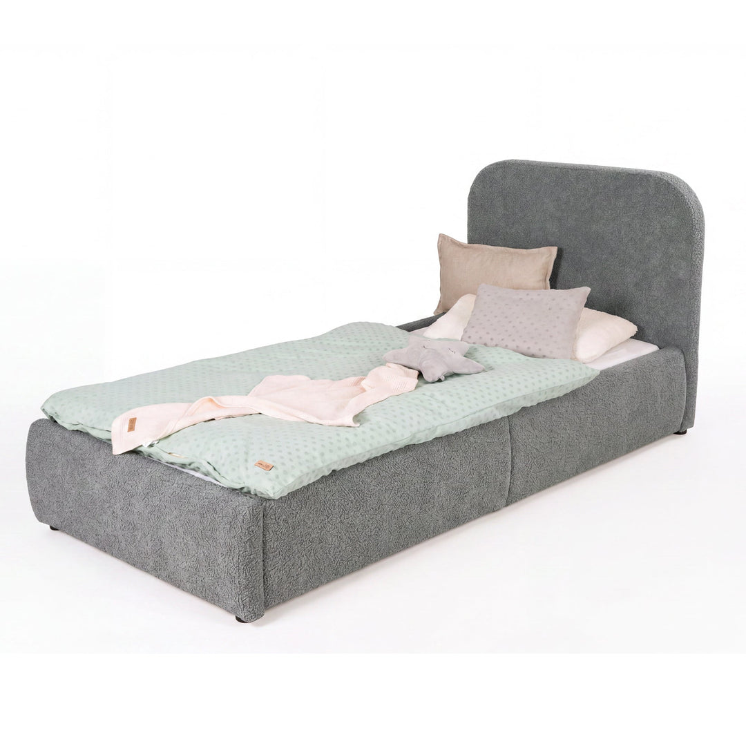 Grey bouclé children's bed with fall protection seen from the foot end, mint bed linen, cut-out image.