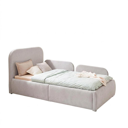 Cama infantil gris claro de bouclé con protección anticaídas, ropa de cama color menta, imagen recortada.