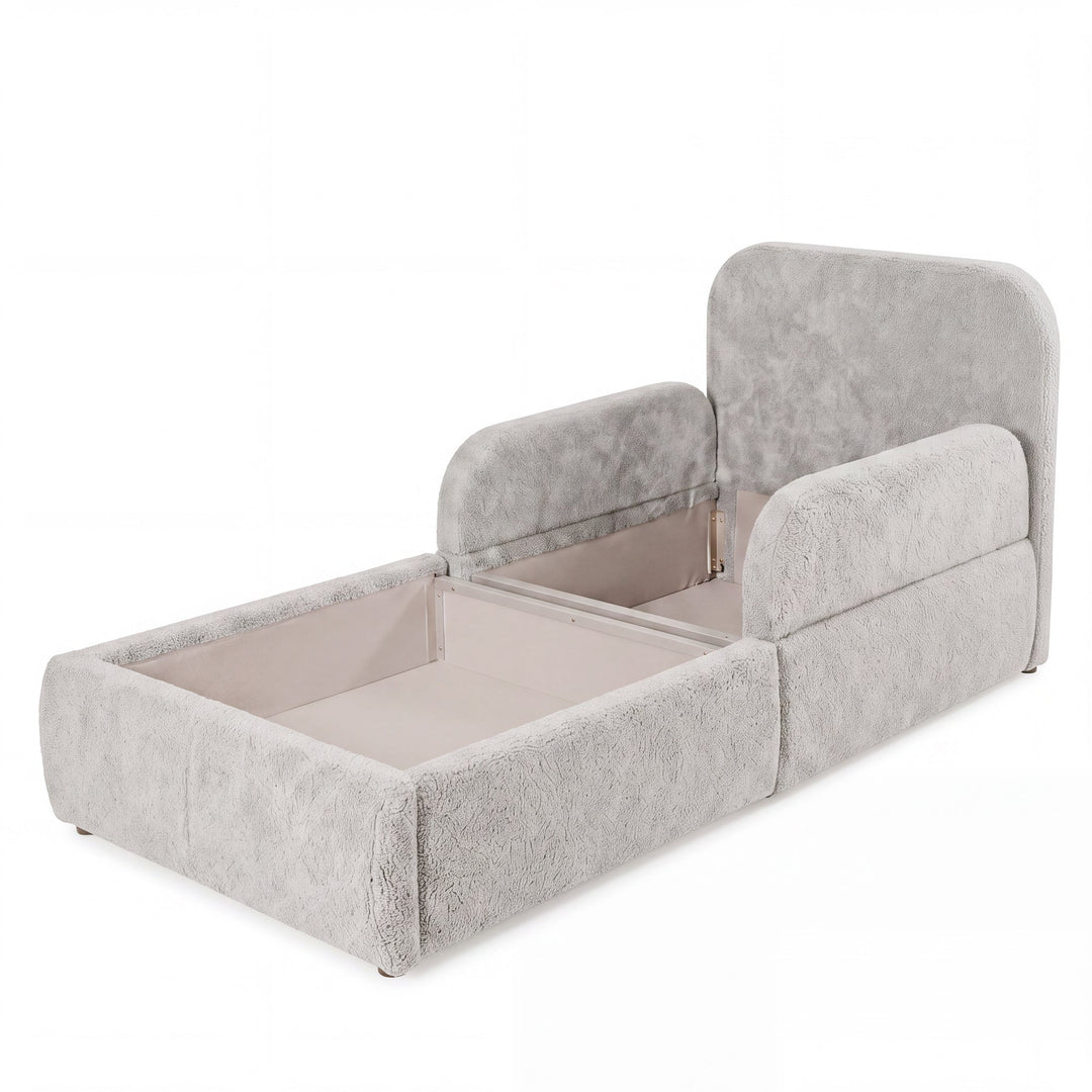 Cama infantil gris claro de bouclé abierta con el arcón de almacenaje visible, imagen recortada.