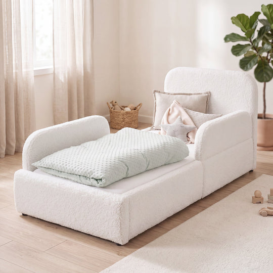 White bouclé children's bed with fall protection, rattan basket and plant in a bright room. Fully AI-generated.