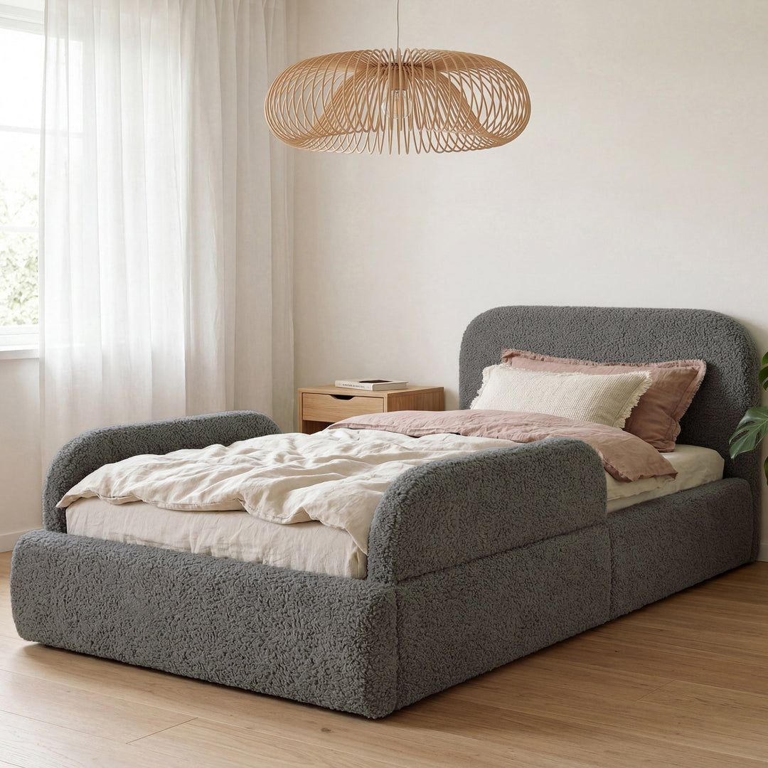 Letto grigio in bouclé con lampada a sospensione in rattan e biancheria rosa nella stanza. Interamente generata con IA.