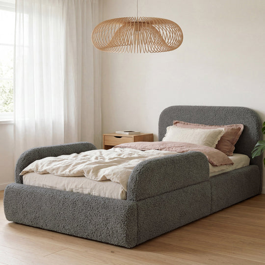 Letto grigio in bouclé con lampada a sospensione in rattan e biancheria rosa nella stanza. Interamente generata con IA.