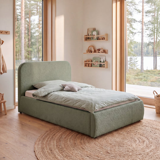 Letto per bambini roba Little Dream verde in una cameretta con vista sul bosco e biancheria verde menta. Interamente generata con IA.