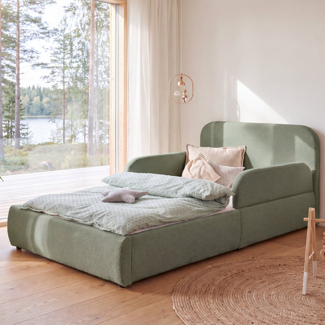 Letto per bambini roba Little Dream verde in una cameretta con vista lago e giostrina appesa sopra il letto. Interamente generata con IA.
