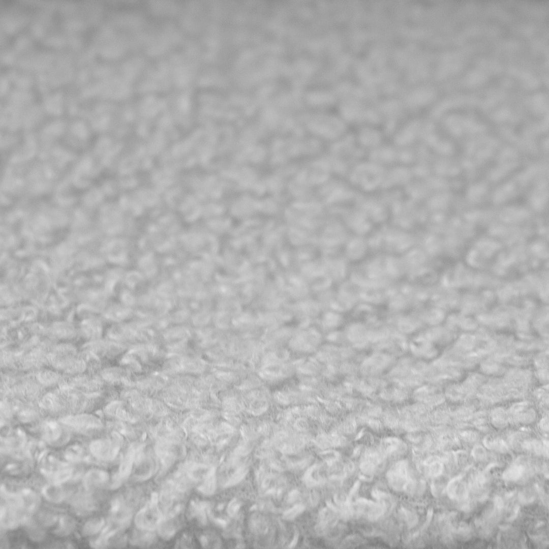 Primo piano del rivestimento in tessuto bouclé grigio chiaro dei pannelli laterali del letto per bambini roba Little Dream.