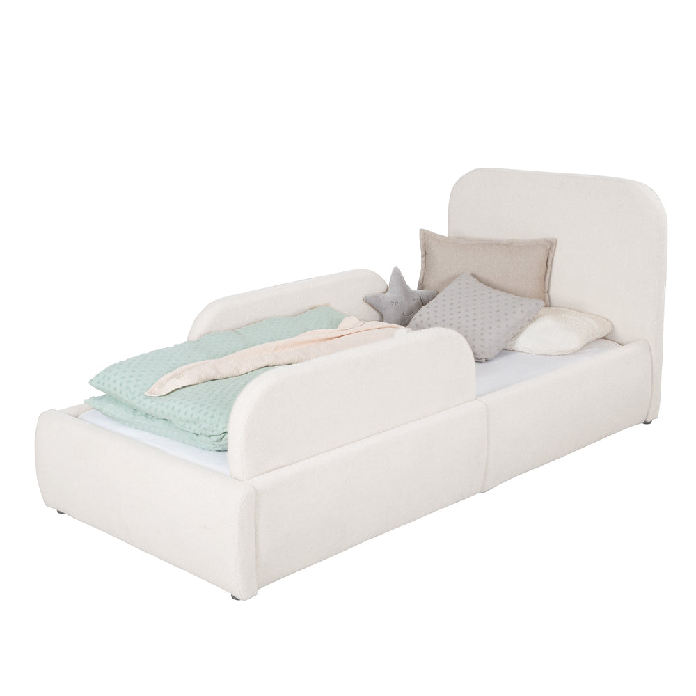Cama infantil roba Little Dream con paneles laterales blancos montados, vestida con ropa de cama de lunares. Generada parcialmente con IA.