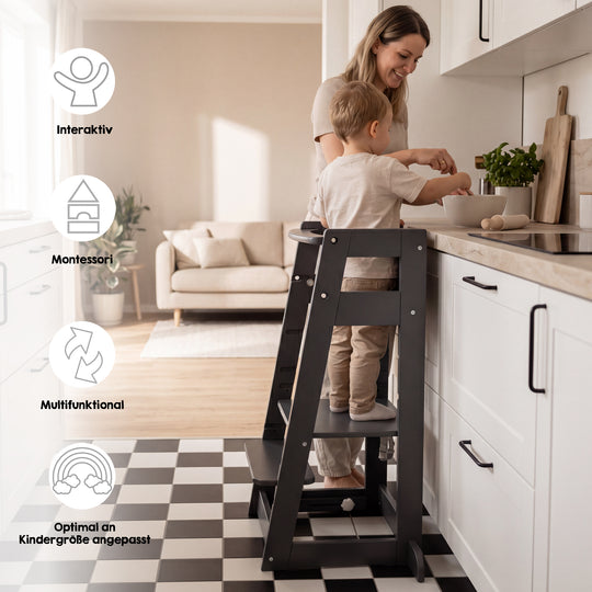 Lifestyle-Bild mit Symbolen 'Interaktiv, Montessori, Multifunktional, Optimal an Kindergröße angepasst': Mutter und Kleinkind rühren gemeinsam in einer Schüssel, das Kind steht im anthrazitfarbenen Lernturm an der Küchentheke.