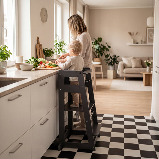 Lifestyle-Bild: leerer Lernturm 'Sit & Step' in Anthrazit an einer Kücheninsel, mit Kräutertopf und Schüssel auf der Arbeitsplatte.
