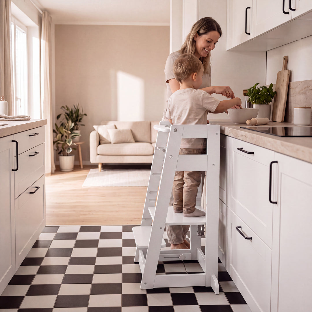 Lifestyle-Bild: leerer Lernturm 'Sit & Step' in Weiß an einer Kücheninsel in einer Küche mit Holzschränken.