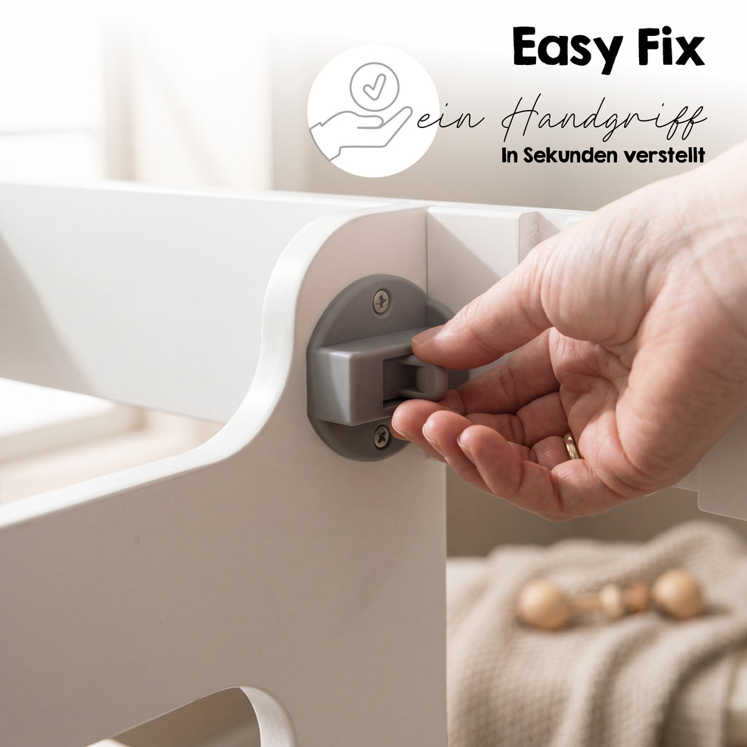 Detailaufnahme mit Schriftzug 'Easy Fix - ein Handgriff - in Sekunden verstellt': Hand bedient den Verstellmechanismus für die Standfläche des weißen Lernturms.
