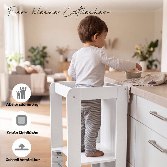 Lifestyle-Bild mit Schriftzug 'Für kleine Entdecker' und Symbolen für Absturzsicherung, große Stehfläche und schnelle Verstellbarkeit; Kleinkind steht im weißen Lernturm an einer Küchenarbeitsplatte.